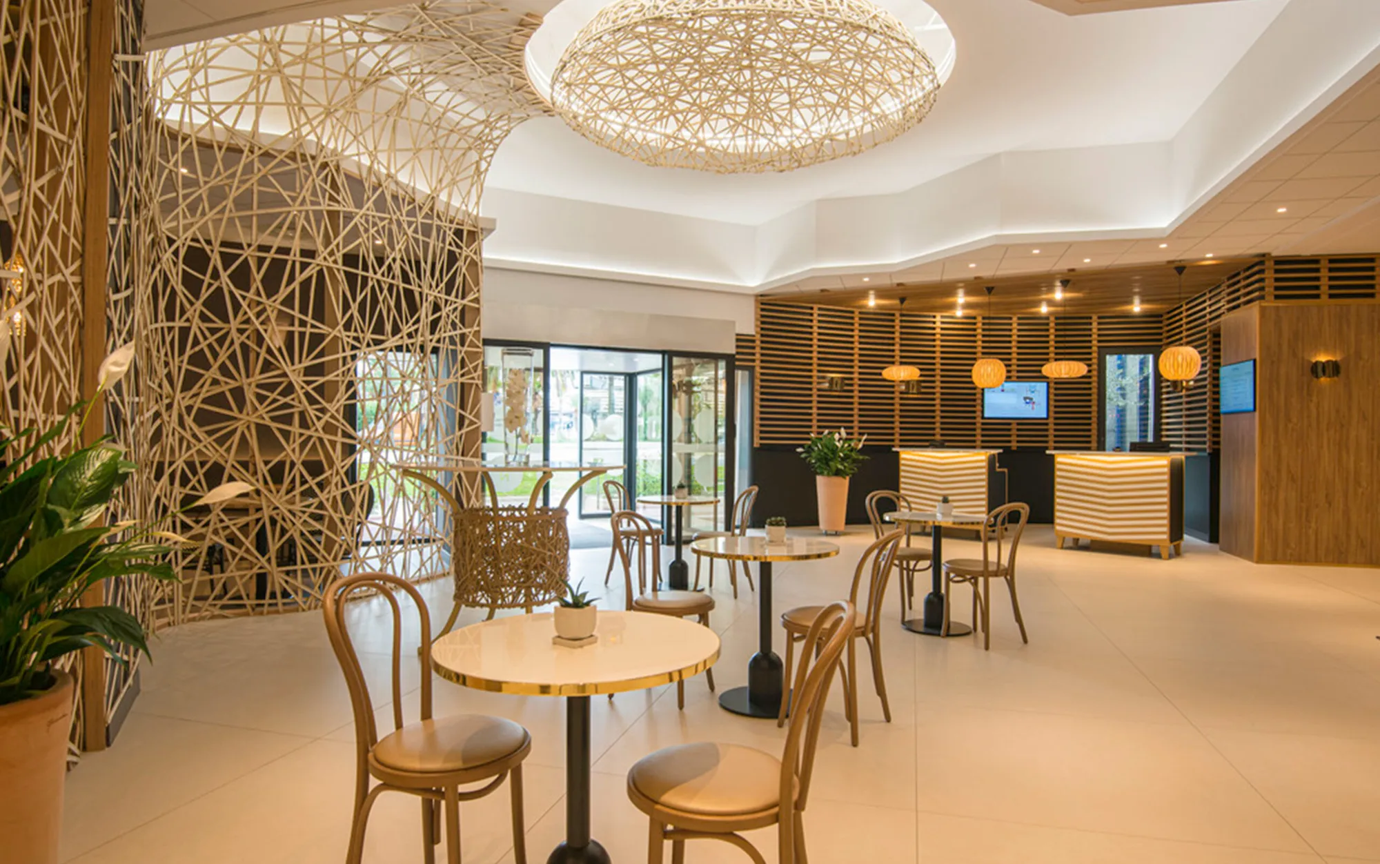 Salon d'accueil avec cloison tressée en bambou et tables en marbre