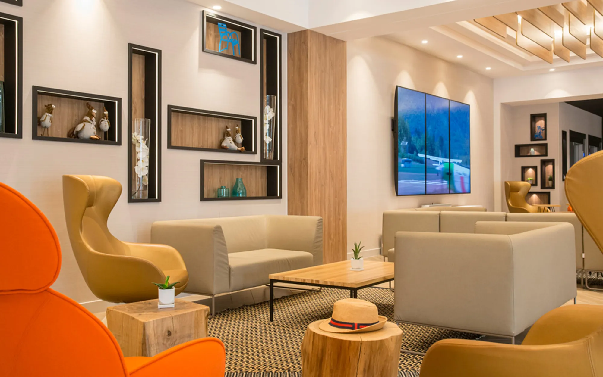 Salon avec fauteuils moutarde et orange, niches en bois